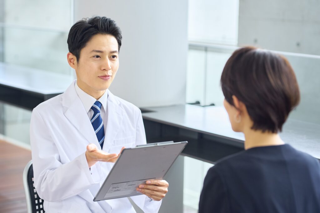 体調の変化について医師に相談する中高年女性